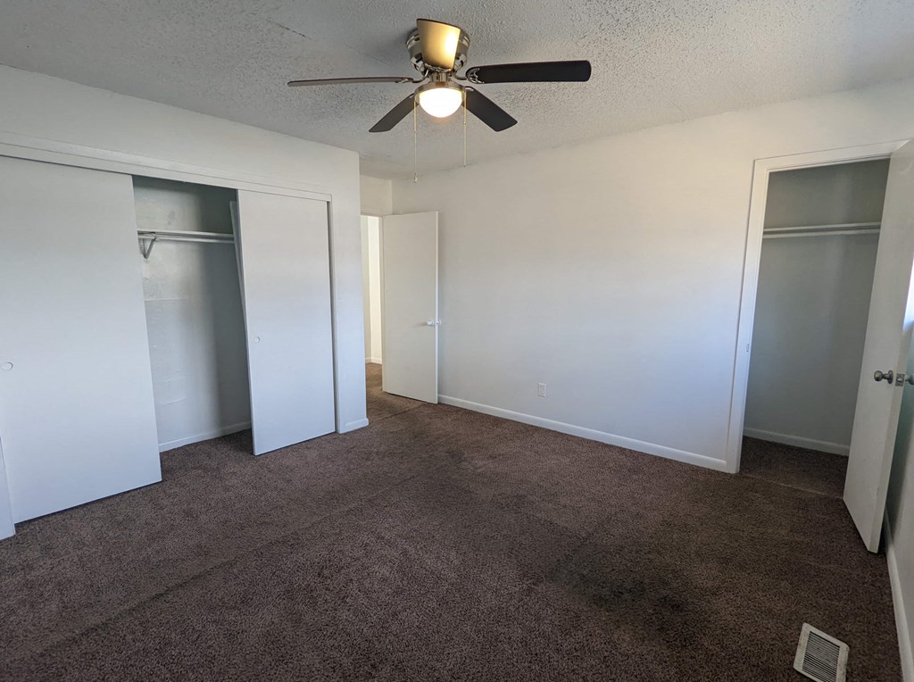 a living room with carpet and a ceiling fan