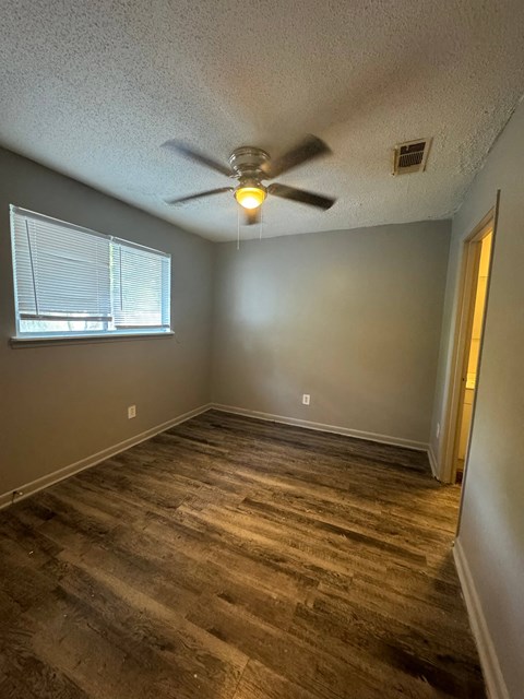 a bedroom with a ceiling fan and a window
