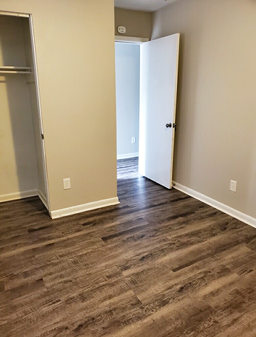 a living room with wood flooring and an open door