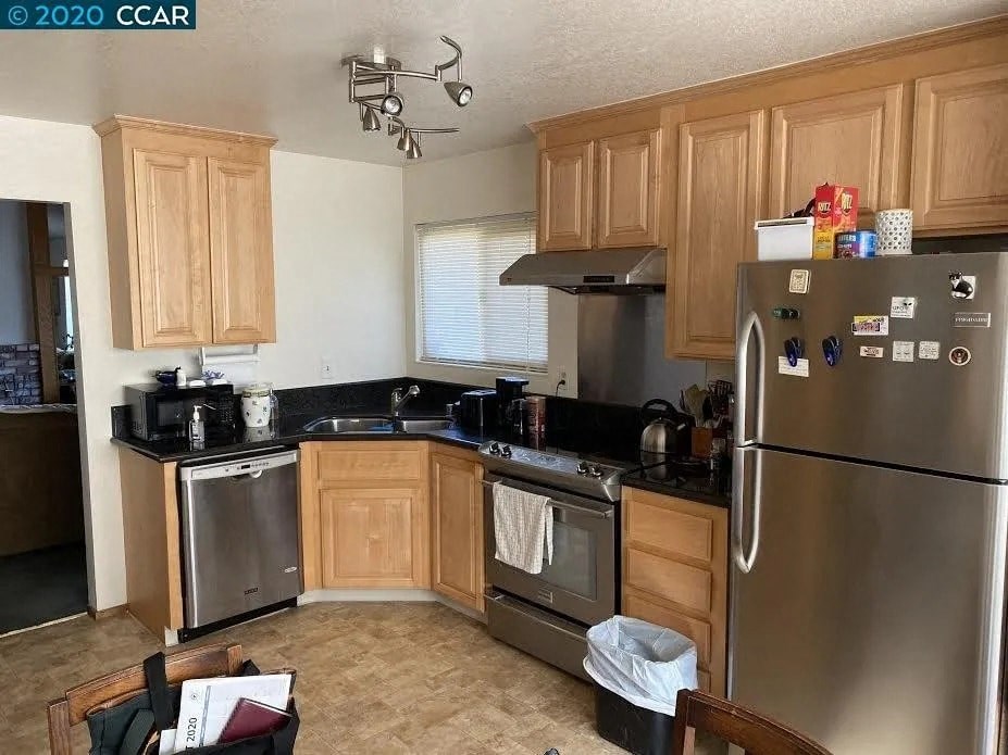 a kitchen with stainless steel appliances and wooden cabinets