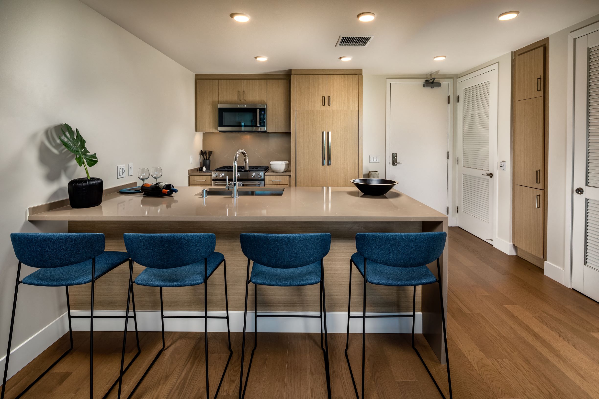 A kitchen with a counter and chairs.