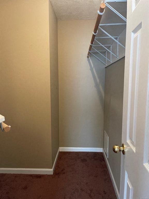 A hallway with a white door and a white wall.