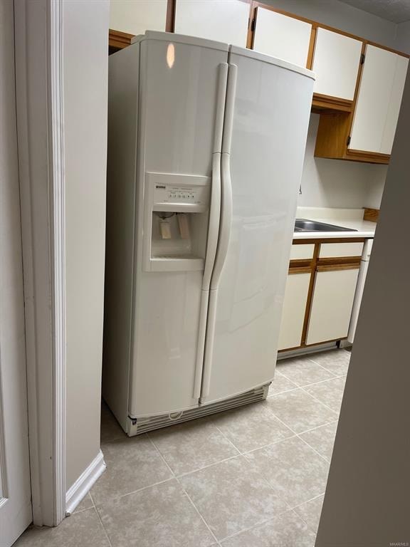 A white refrigerator with a water and ice dispenser in the middle of the door.