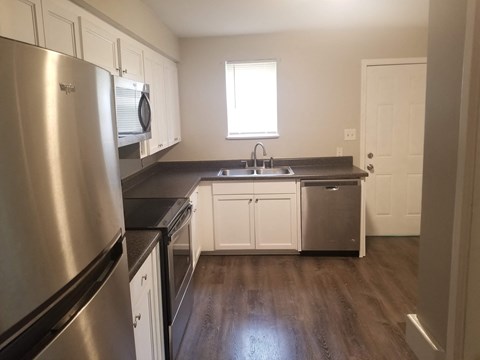 a kitchen with stainless steel appliances and white cabinets