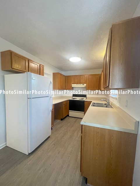 a kitchen with white appliances and wooden cabinets