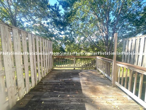 a wooden deck with trees in the background