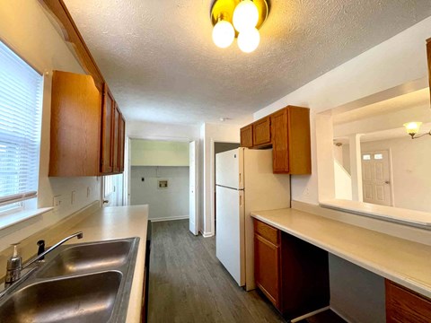 a kitchen with wooden cabinets and a sink and a refrigerator