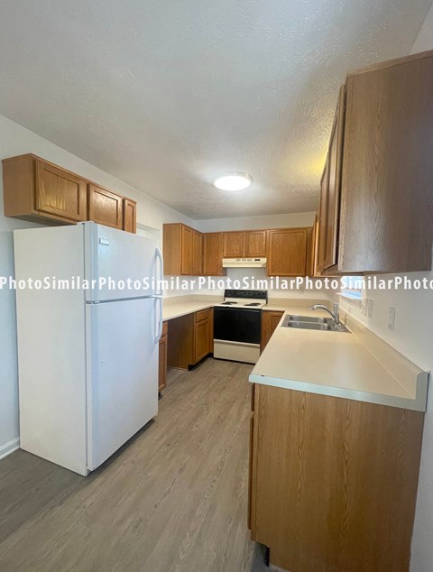a kitchen with white appliances and wooden cabinets
