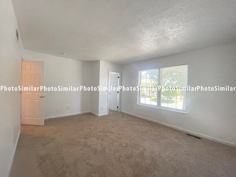 the living room of the 2400 sqft home has a large window and carpet