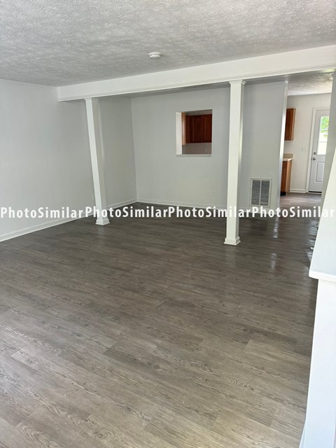 a living room with white walls and a wood floor