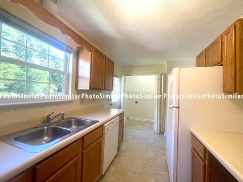 A kitchen with wooden cabinets and a white refrigerator.