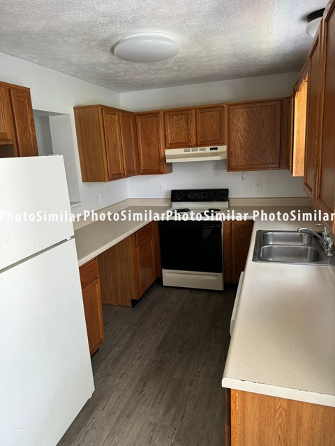 a kitchen with wood cabinets and white counter tops and a black stove