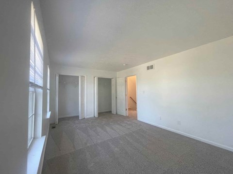 an empty living room with white walls and carpet