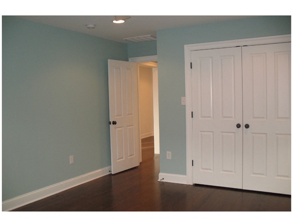a blue room with two white doors and a door to a closet