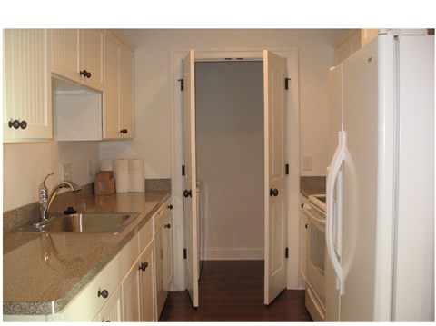 a kitchen with white cabinets and a sink and a refrigerator