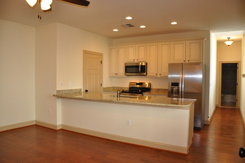 a kitchen with a granite counter top and a stainless steel refrigerator