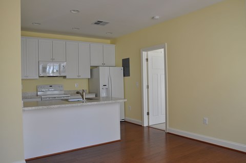 A kitchen with white cabinets and a white refrigerator.