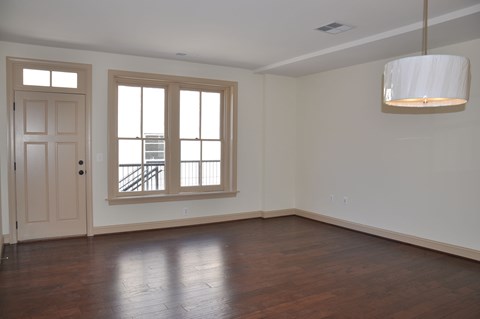 an empty living room with a white door and window