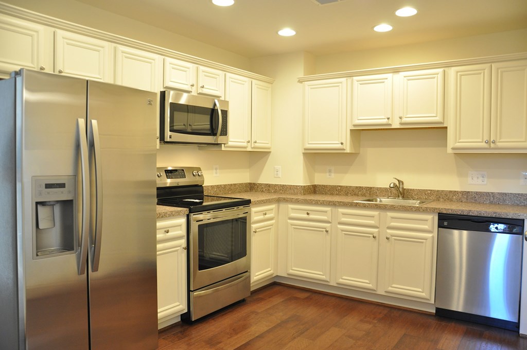 a kitchen with stainless steel appliances and white cabinets