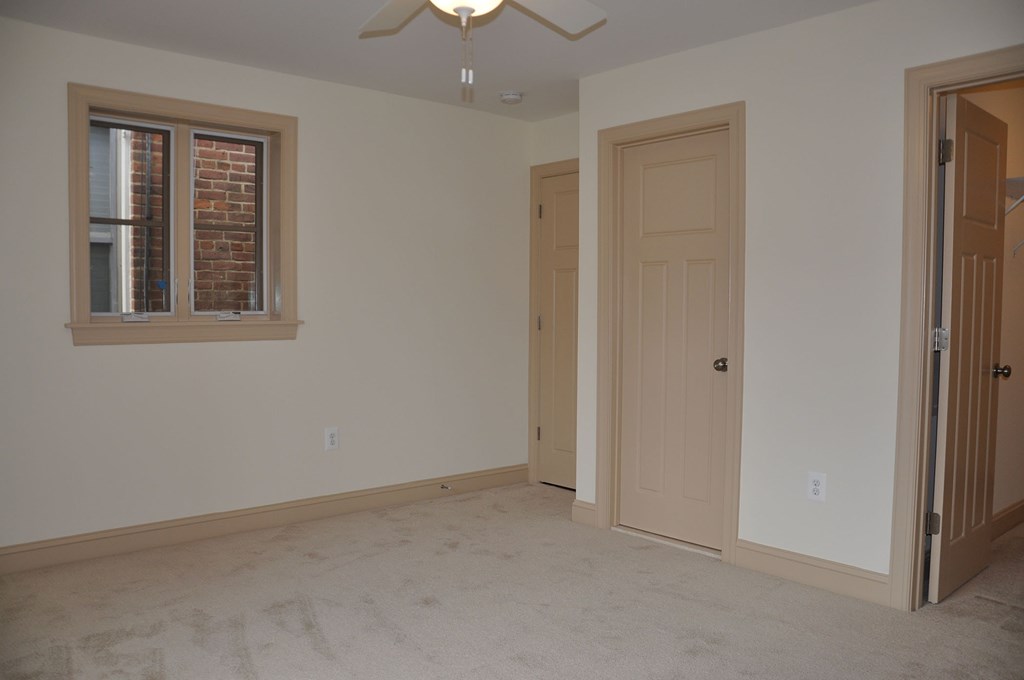 an empty room with a door and a window and a closet