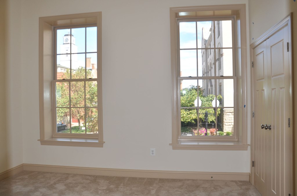 a living room with two windows and a door