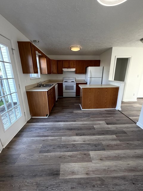 A kitchen with wooden cabinets and a white refrigerator.