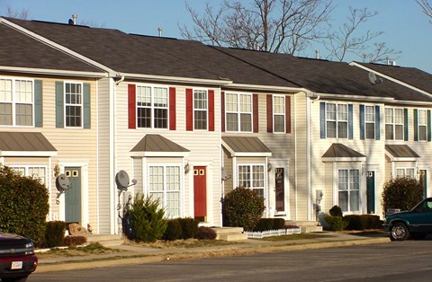 A row of houses with different colored front doors.