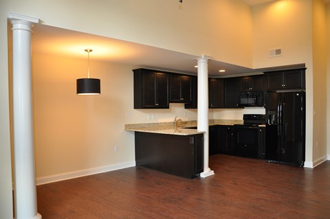 a kitchen with black cabinets and an island in the middle of a room