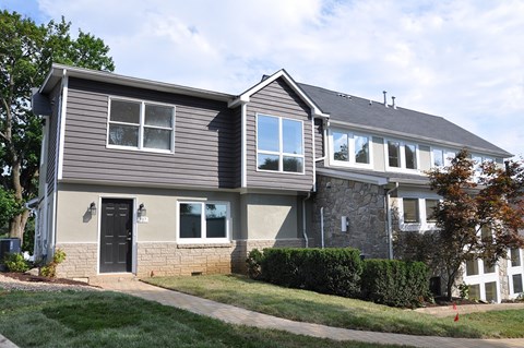 A house with a grey siding and a black door.