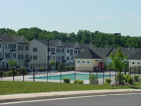 a swimming pool in front of a row of apartment buildings
