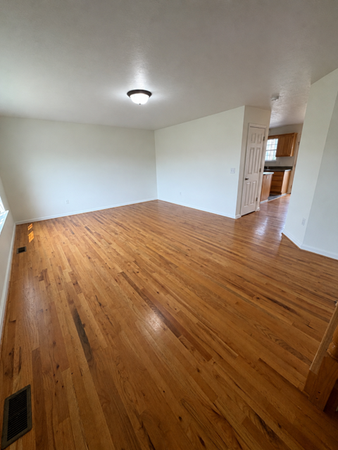 A room with wooden flooring and a white ceiling.