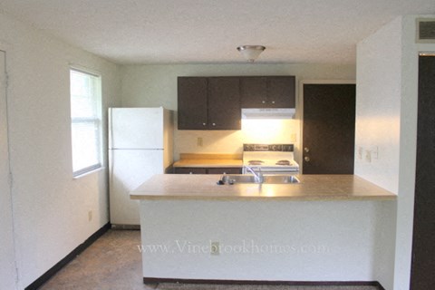 A kitchen with a white fridge and a counter top.