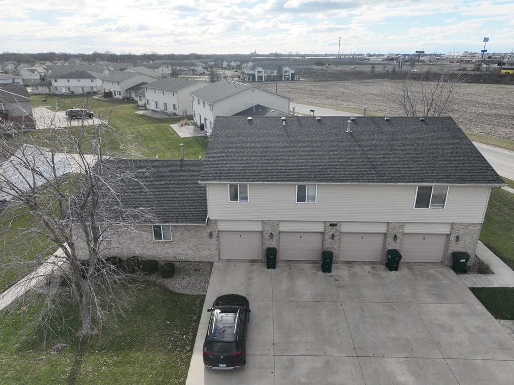 an aerial view of a house with a car parked in the driveway