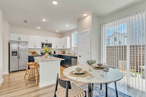 an open kitchen and dining area with a table and chairs