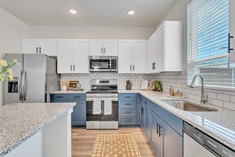 a white and blue kitchen with a sink and a stove