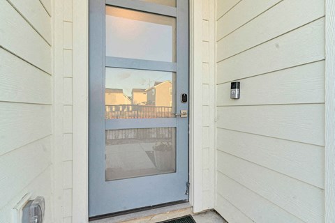 A blue door is on the left side of a white wall.