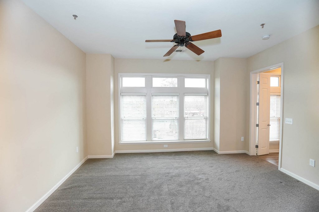 a living room with a ceiling fan and a large window