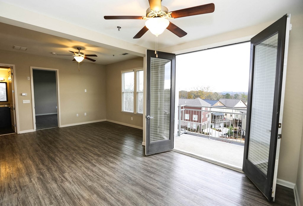 a living room with a large window and a ceiling fan