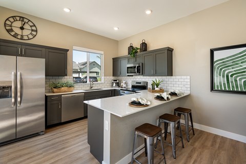updated kitchen with stainless steel appliances and a large island with 3 stools