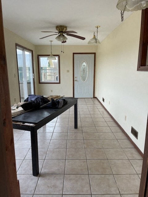 a living room with a table and a ceiling fan
