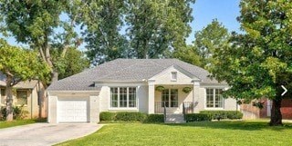 a white house with a yard and trees