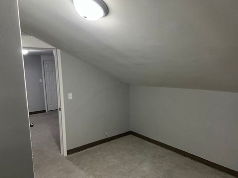 A room with a white door and a light on the ceiling.