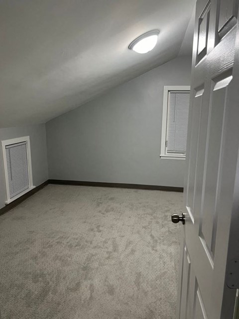 A room with a carpeted floor and a white door.