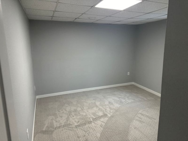 A room with a carpeted floor and a ceiling with lights.