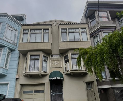 A building with a green awning and a phone number on it.
