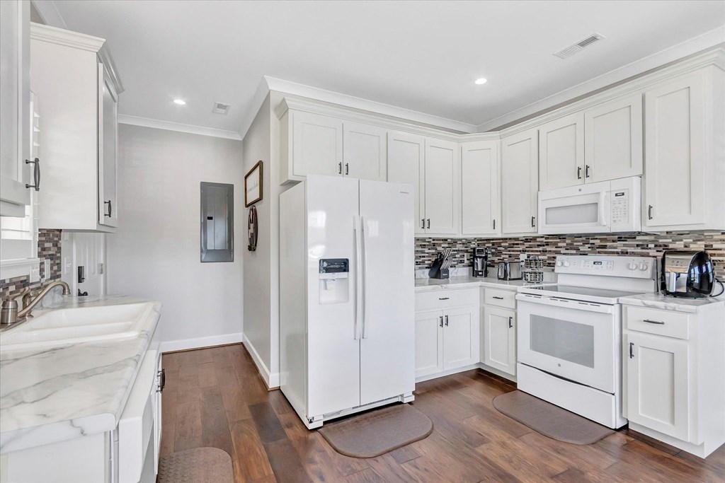 a white kitchen with white appliances and white cabinets