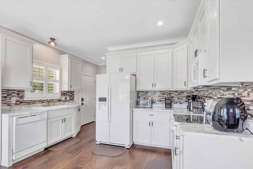 a white kitchen with white cabinets and a washing machine