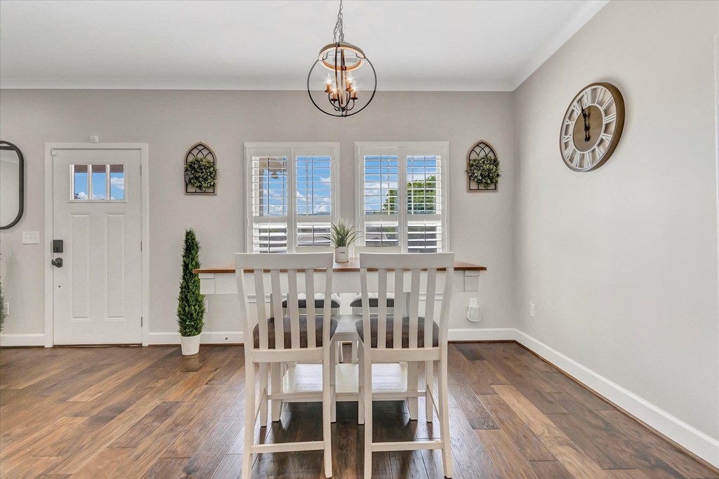 a dining room with a white table and chairs     and a door