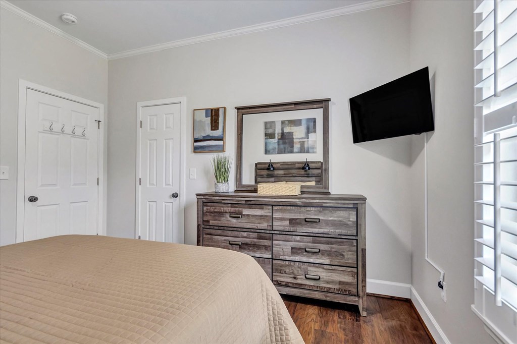 a bedroom with a bed and a dresser with a tv