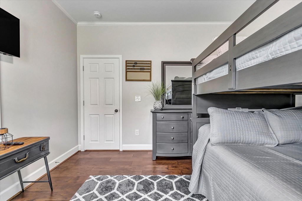 a bedroom with a bunk bed and a desk with a mirror